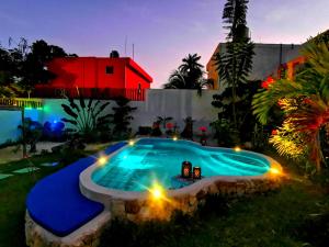a swimming pool with lights in a yard with a house at Mayan Majesty Boutique Hotel in Valladolid