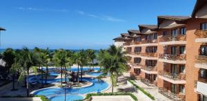 an aerial view of a resort with a pool and palm trees at Manacá Apartamentos , Kariri Beach , Cumbuco in Cumbuco