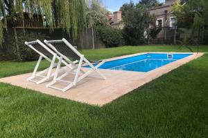 2 tumbonas junto a la piscina en Casa en Chacras Mendoza , Casa LOLA en Luján de Cuyo