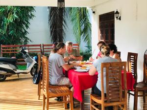 a group of people sitting at a table eating food at Freedom Lodge Yala in Tissamaharama