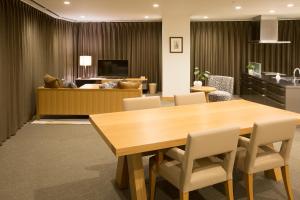 uma sala de conferências com uma mesa de madeira e cadeiras em 3 Wellness em Okayama