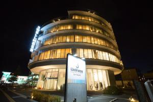 a tall building with a sign in front of it at 3 Wellness in Okayama