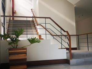 a staircase with wooden railings and a white wall at Soleo Inn in Baguio