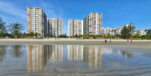 a beach with tall buildings and reflections in the water at POKO SUITE @ TIMURBAY in Kuantan