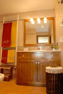 W łazience znajduje się drewniana umywalka i lustro. w obiekcie Mas Mallol w mieście Puigcerdà