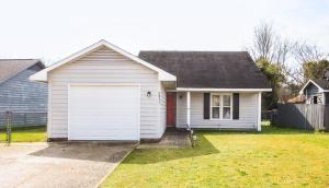 a white house with a garage in a yard at Cozy cottage feel, 5 mins from Ft. Bragg in Fayetteville