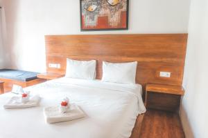 una camera da letto con un grande letto bianco con due asciugamani bianchi di Gili One Resort a Gili Trawangan