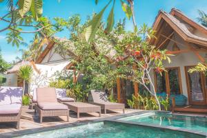 a villa with a swimming pool in front of a house at Gili One Resort in Gili Trawangan