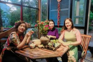 a group of three women sitting around a table at Yellow Farm homestay in Ðông Tác (1)