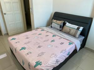 Una cama con un edredón rosa encima. en Spice Tunas House en Bayan Lepas