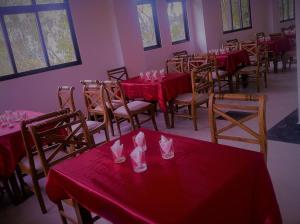 a room with tables and chairs with red table cloths at Himagira Hotel in Bandarawela