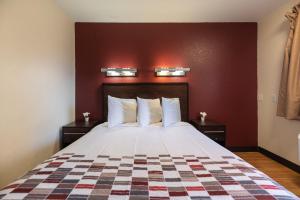 a hotel room with a bed with a checkered blanket at California Inn and Suites, Rancho Cordova in Rancho Cordova