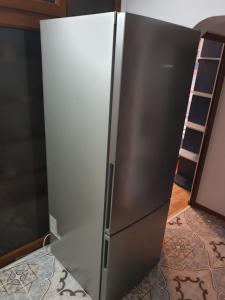 a stainless steel refrigerator in a kitchen with a ladder at Rozelor in Mangalia