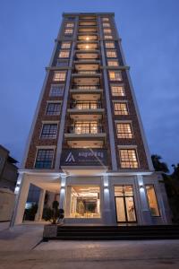 a tall building with a store in front of it at TK VIEW HOTEL & APARTMENT in Phnom Penh
