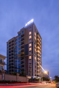 a tall building with a sign on top of it at TK VIEW HOTEL & APARTMENT in Phnom Penh