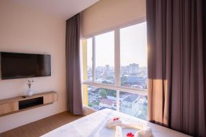a hotel room with a bed and a large window at TK VIEW HOTEL & APARTMENT in Phnom Penh