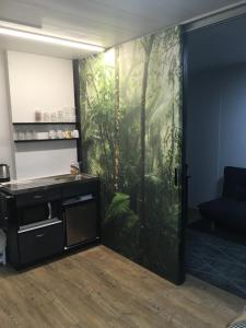 a room with a sliding door with a jungle mural at Suburban Studio in Hamilton