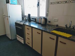 a kitchen with a sink and a stove and a refrigerator at Valle Encantado in Monte Hermoso