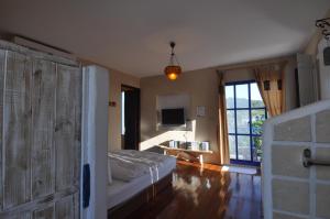 una camera da letto con un letto, una tv e una finestra di Little Path Kenting a Eluan