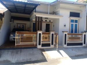 a house with two wooden gates in front of it at Budi Asih Guest house Syariah in Duku