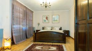 - une chambre avec un lit et un lustre dans l'établissement Toscana Villa, à Snagov