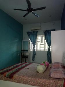 a bedroom with a bed and a ceiling fan at GERIK BANDING HOMESTAY in Gerik