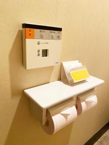 a toilet with a paper dispenser on a wall at Hotel Venus Ritz (Adult Only) in Seto