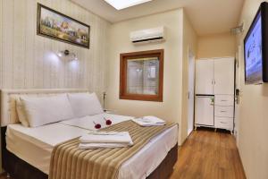 a bedroom with a bed with two towels on it at Gh Suites Taxim Hotel in Istanbul