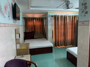 a small room with two beds and a tv at Minh Tuan Hotel in Ho Chi Minh City