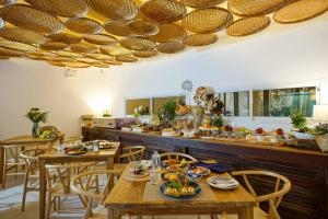 a kitchen with wooden tables and chairs with food on them at NORN Nimman13 Boutique Hotel Chiang Mai in Chiang Mai