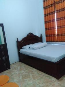 um quarto com uma cama e uma cabeceira em madeira em Wisma Kahyangan em Baubau