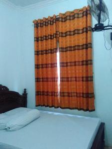 a bedroom with a bed and a curtain at Wisma Kahyangan in Baubau