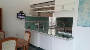 a kitchen with a green counter top and a table at residencia 2 in Mazatlán