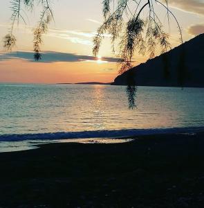 a sunset over a body of water with the sun setting at Sempati Apart in Mesudiye