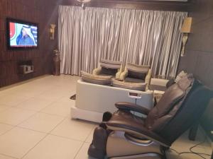 Sala de espera con silla y TV en Orans Suites 2, en Yeda
