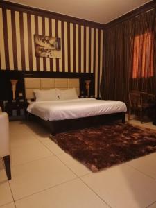 1 dormitorio con cama y pared a rayas en Orans Suites 2, en Yeda