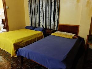 2 camas en una habitación con ventana en Latanier Beach Hotel, en Grand Baie
