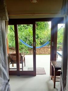 a sliding glass door with a hammock outside at Bamboo Bali in Amed