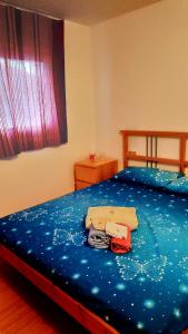 een slaapkamer met een bed met blauwe lakens en kleding bij A due passi dal cielo in Passo del Tonale