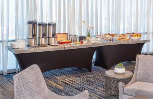Crowne Plaza Boston - Woburn, an IHG Hotel في وبورن: طاولة بوفيه عليها طعام في غرفة فندق