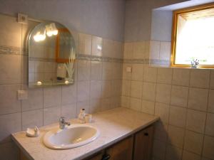 a bathroom with a sink and a mirror and a window at Gîte Les Sauvasses in Puy-Sanières