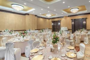 a banquet hall with white tables and white chairs at Albuquerque Crowne Plaza by IHG in Albuquerque