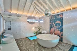 uma casa de banho com uma grande banheira e 2 WC em The Standard, Huruvalhi Maldives em Raa Atoll