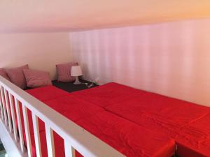 - une chambre avec un lit et une couverture rouge dans l'établissement 2 pièces à 300m de la grande plage - 2 à 5 couchages, à Saint-Jean-de-Luz