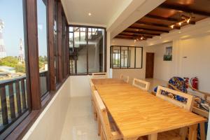 a large wooden table in a room with a balcony at Old Town Inn Maldives in Gaafaru