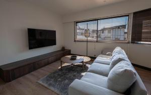 a living room with a couch and a tv at Shiro Nozawa in Nozawa Onsen