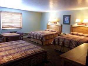 a hotel room with two beds and a table at New Summit Inn in Frisco