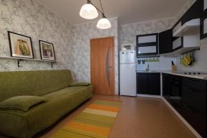 a living room with a couch and a kitchen at OK! Розы Люксембург in Tomsk