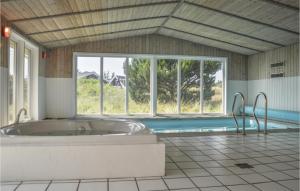 baño grande con bañera y piscina en Pet Friendly Home In Ringkbing With Wifi, en Klegod