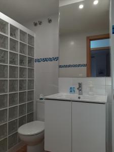 Baño blanco con aseo y lavamanos en Encanto de Tarifa, en Tarifa